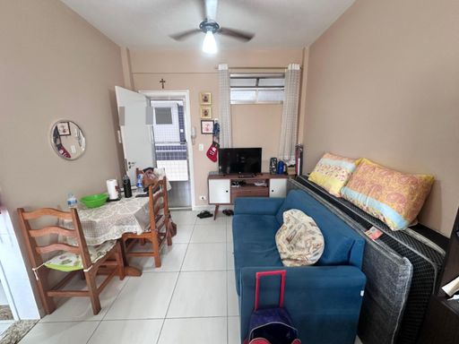 Sala living ampla e bem iluminada com um sofá e ventilador de teto.