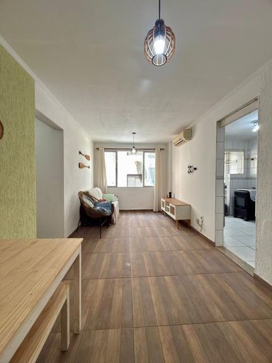 Sala ampla e bem iluminada com ar-condicionado e uma janela com vista para o mar.