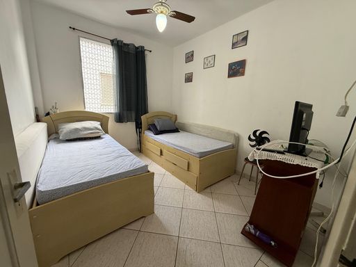 Dormitório com 2 camas de solteiro e ventilador de teto.