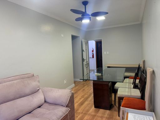 Sala de 2 ambientes com uma mesa de jantar, sofá, ventilador de teto e ar-condicionado.