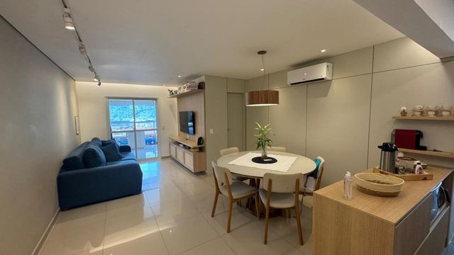 Sala ampla de 2 ambientes com um sofá, mesa de jantar e ar-condicionado.