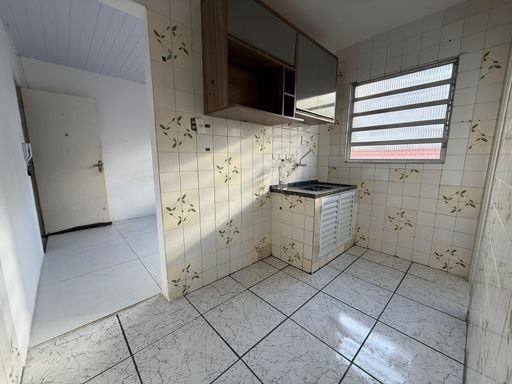 Cozinha bem iluminado com pia e gabinete.