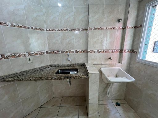 Cozinha americana com uma pia integrada com a área de serviço.