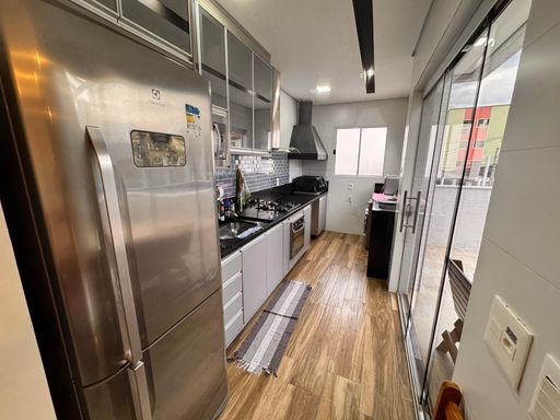 Cozinha integrada à piscina, completamente planejada, com fogão, coifa e geladeira.