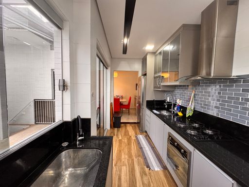 Cozinha integrada à piscina, completamente planejada, com fogão, coifa e geladeira.