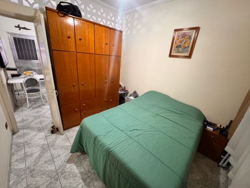 Dormitório com uma cama de casal e guarda-roupa.