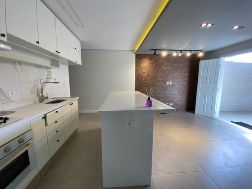 Cozinha americana com planejados e cooktop.