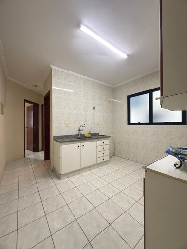 Cozinha com uma pia e gabinete e armários brancos.