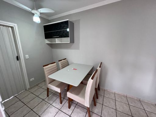 Cozinha americana com mesa de 4 lugares e ventilador de teto.