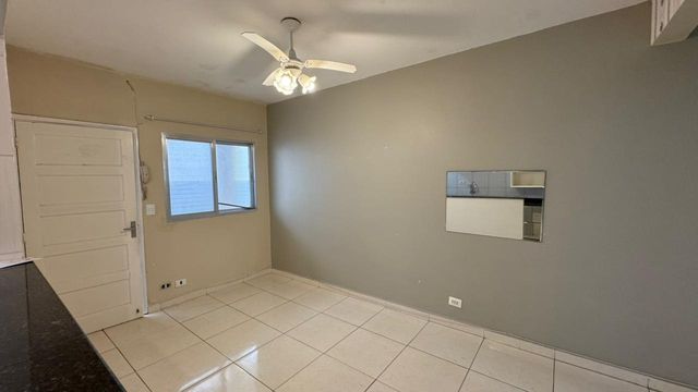 Sala espaçosa e bem iluminada com ventilador de teto.