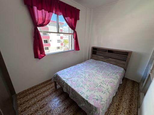 Dormitório muito bem iluminado com uma cama de casal e uma janela com vista para rua.