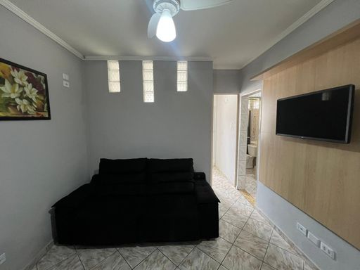 Sala com sofá e ventilador de teto.