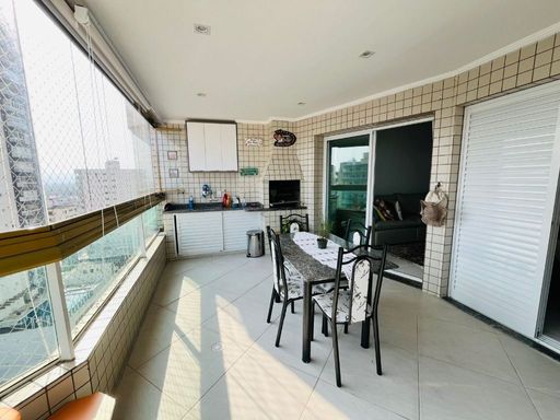 Sacada gourmet envidraçada com vista para o mar.