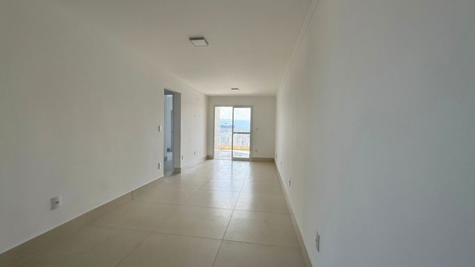 Sala bem iluminada de dois ambientes com uma sacada gourmet.