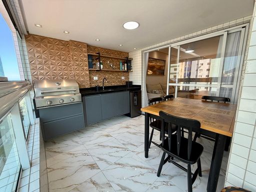 Sacada gourmet envidraçada com vista para o mar.