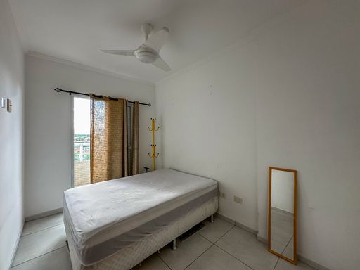 Dormitório com 1 cama de casal, ventilador de teto e acesso à sacada gourmet.
