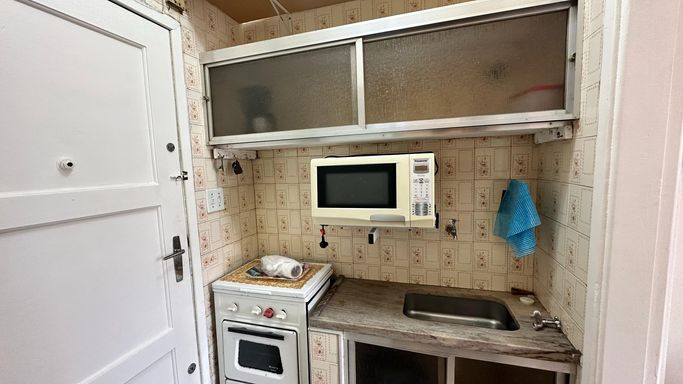 Cozinha com uma pia, fogão, micro-ondas e geladeira.
