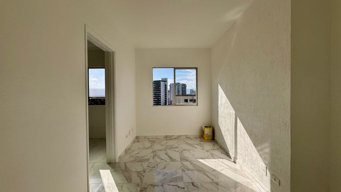 Sala bem iluminada com janela grande com vista livre.