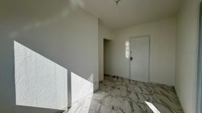 Sala bem iluminada com janela grande com vista livre.