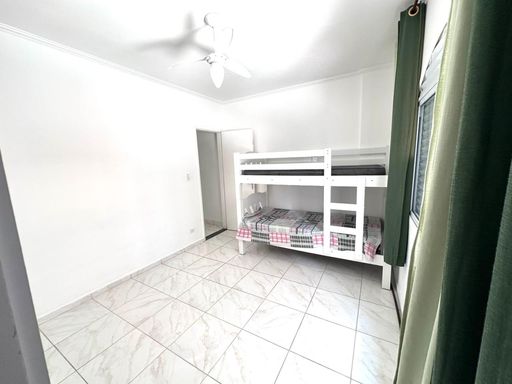 Dormitório espaçoso e bem iluminado com um beliche e ventilador de teto.