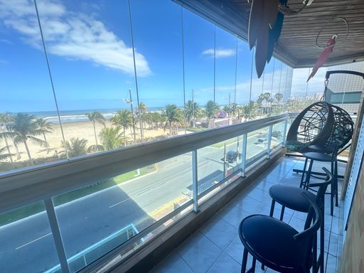 Sacada gourmet envidraçada com vista para o mar.