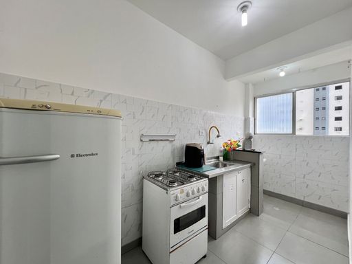 Cozinha com uma pia e gabinete embutido, fogão e geladeira.