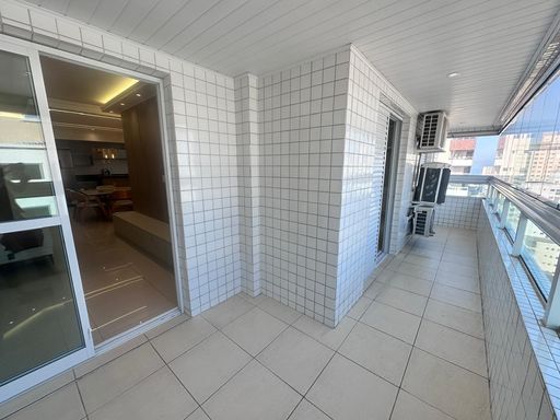 Sacada gourmet envidraçada com churrasqueira a carvão e vista livre.