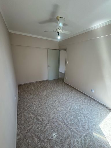 Dormitório espaçoso e bem iluminado com um ventilador de teto.