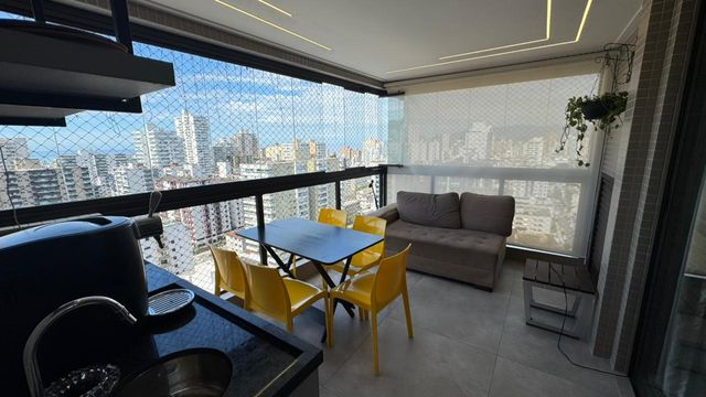 Sacada gourmet envidraçada com vista para o mar.