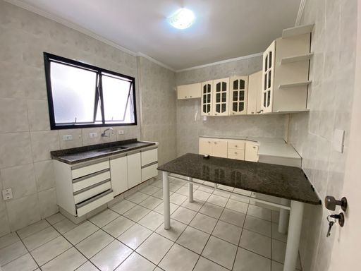 Cozinha com armários brancos embutidos.