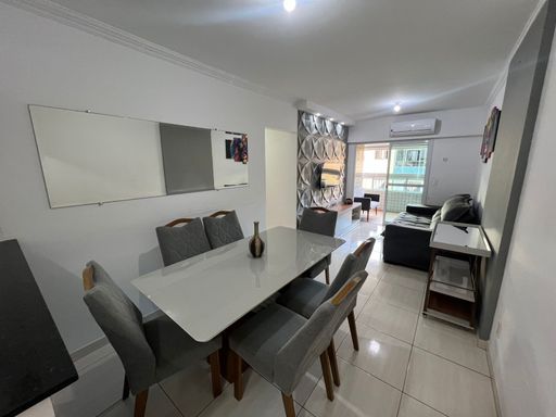 Sala de 2 ambientes com uma mesa de jantar, sofá e ar-condicionado.