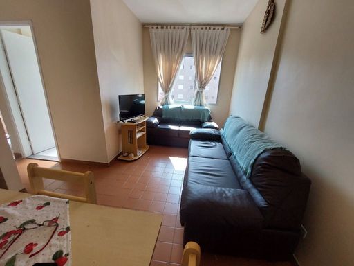 Sala bem iluminada com dois sofás e uma mesa de jantar.