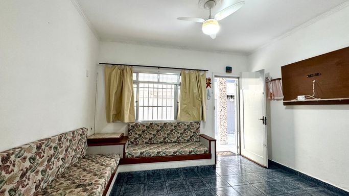 Sala bem iluminada, dois sofás embutidos e ventilador de teto.