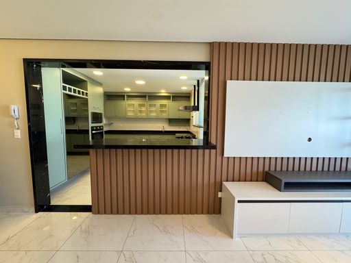 Sala de dois ambientes com nichos na parede, ar-condicionado, sofá e acesso à sacada gourmet.