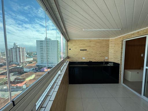 Sacada envidraçada com vista para o mar.