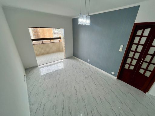 Sala bem iluminada de 3 ambientes com uma sacada envidraçada.