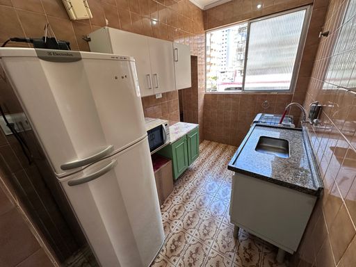 Cozinha com uma geladeira, pia e fogão.