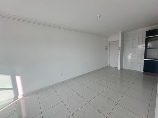 Sala de 2 ambientes com painel de TV e paredes brancas e acesso a sacada gourmet.
