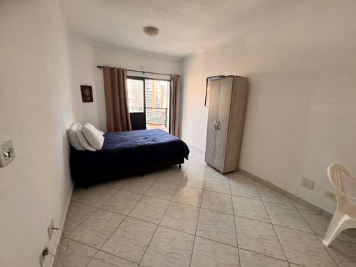 Sala living ampla e bem iluminada com uma sacada e ventilador de teto.