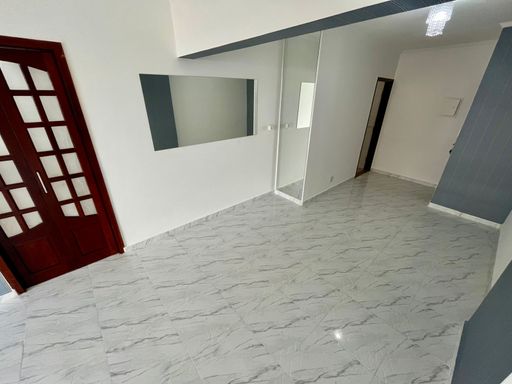 Sala bem iluminada de 3 ambientes com uma sacada envidraçada.