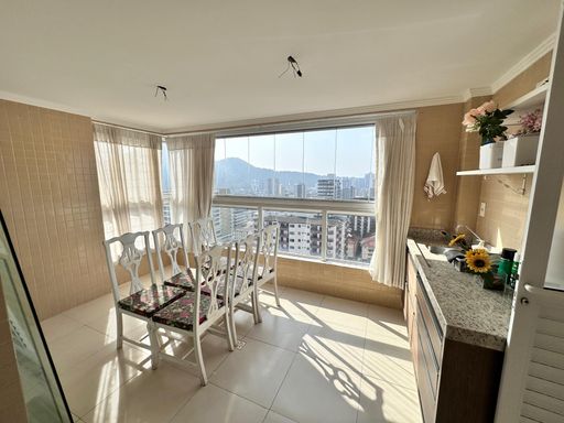 Sacada envidraçada com vista para o mar.