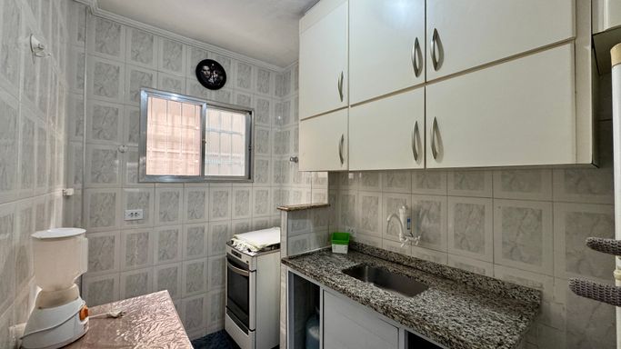 Cozinha com armários, pia, gabinete, fogão e geladeira.