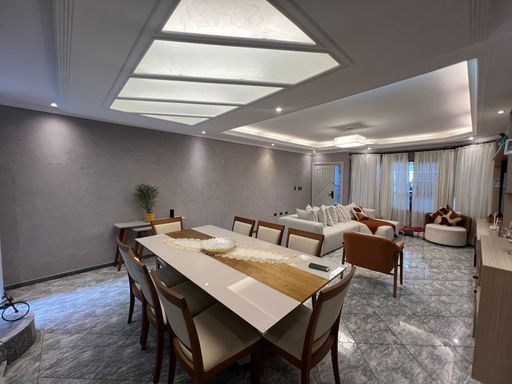 Sala ampla de 2 ambientes com teto rebaixado em gesso com iluminação em LED.