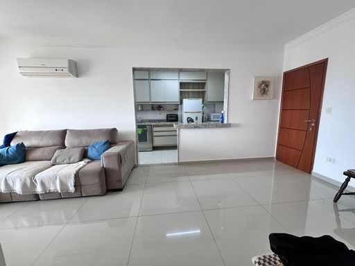 Sala de 2 ambientes com muita iluminação natural e sofá e ar-condicionado.