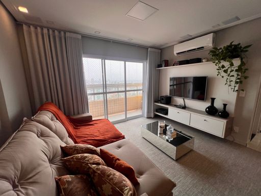 Sala ampla de 02 ambientes com sofá, mesa de jantar para seis pessoas, ar-condicionado e acesso a sacada gourmet.
