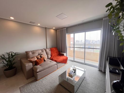 Sala ampla de 02 ambientes com sofá, mesa de jantar para seis pessoas, ar-condicionado e acesso a sacada gourmet.