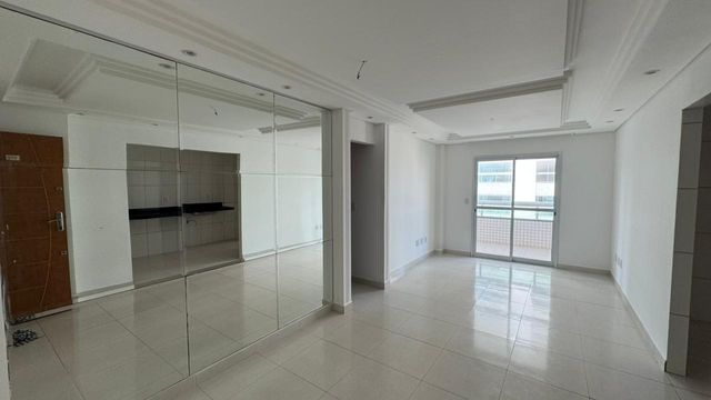 Sala ampla de 2 ambientes com teto rebaixado com parede espelhada.