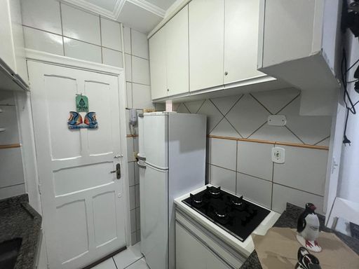 Cozinha americana planejada com uma geladeira branca.