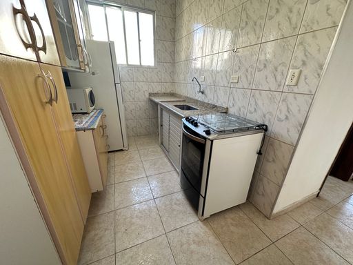 Cozinha com uma, pia, gabinete embutido, fogão e armários.