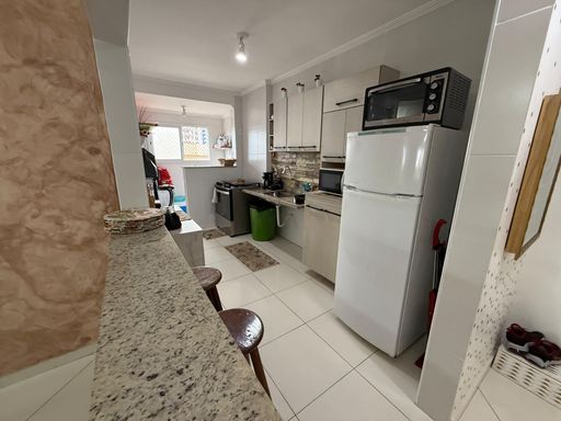 Cozinha americana planejada com fogão e geladeira branca.
